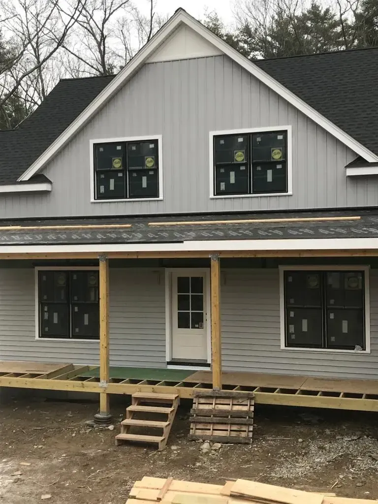 New construction home with freshly installed windows and gray board-and-batten siding