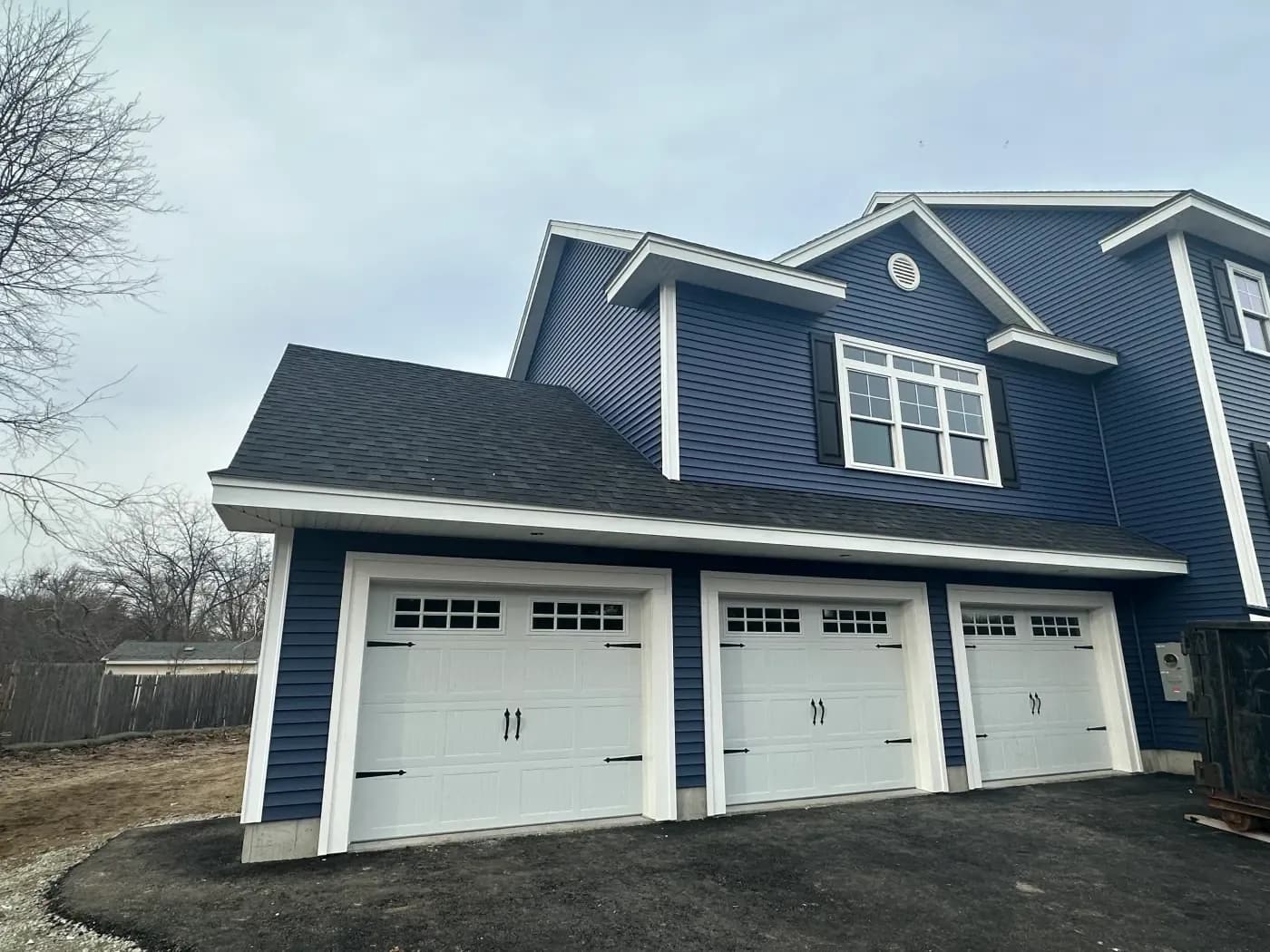 Navy home with new garage doors and entry door installed by FBS Construction