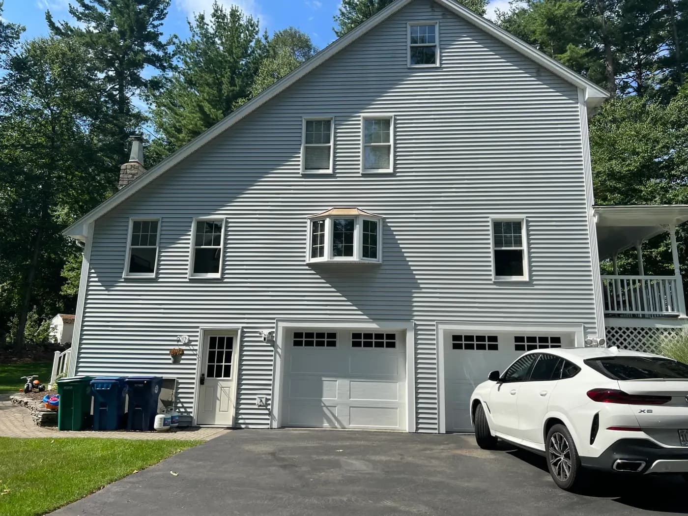 Gray siding installation on a multi-level home with attached garage