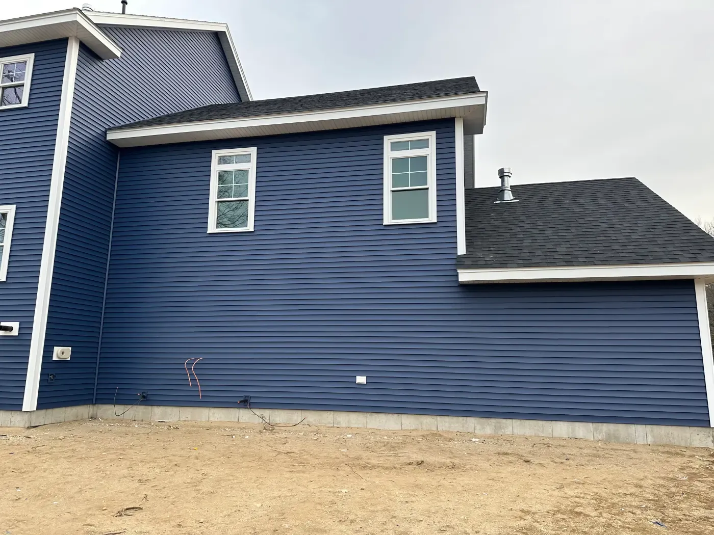 Navy blue lap siding installation on a new home exterior
